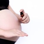 Une femme enceinte en train d'utiliser le meilleur antimoustique pour bébé